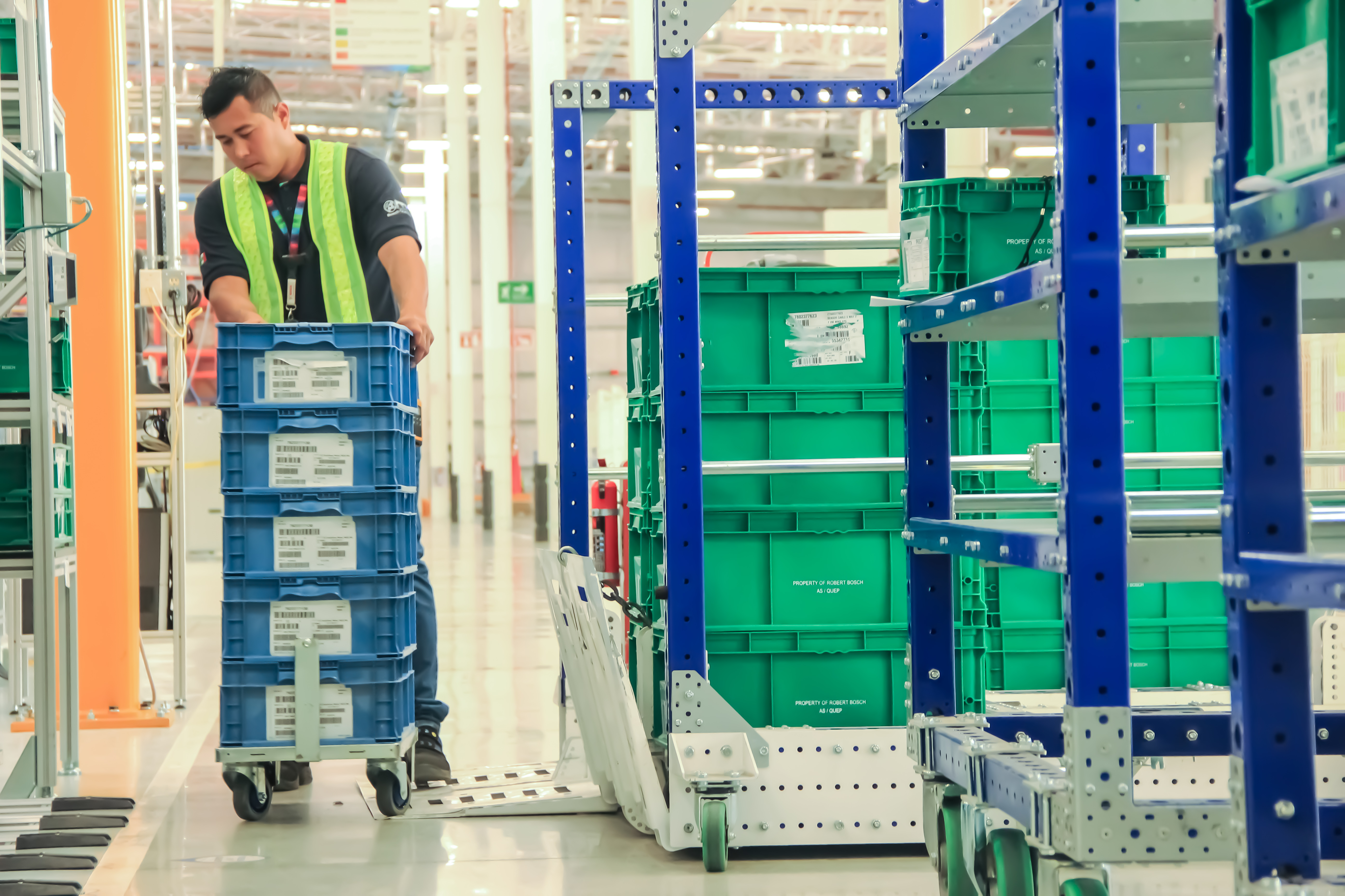 A operator moving a FlexQube cart with totes.